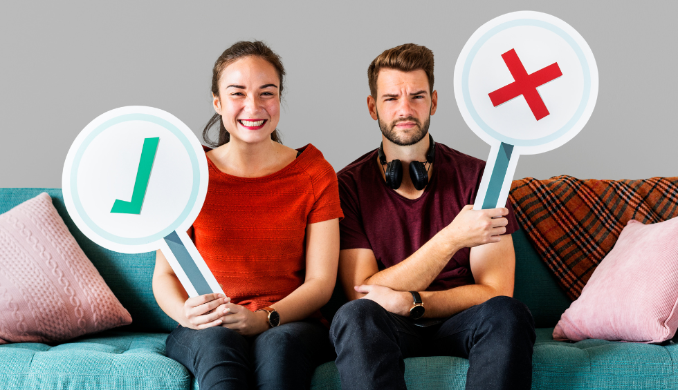 Smiling woman and skeptical man holding large signs with a green checkmark and red X, showing pros and cons