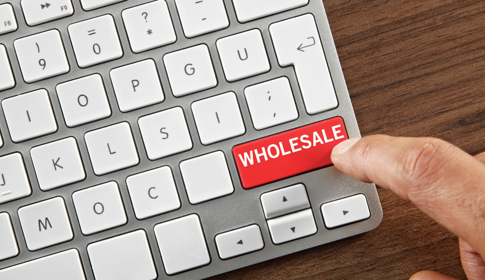 Finger pressing a red “WHOLESALE” key on a keyboard, symbolizing buy wholesale to save more on a pound of bud