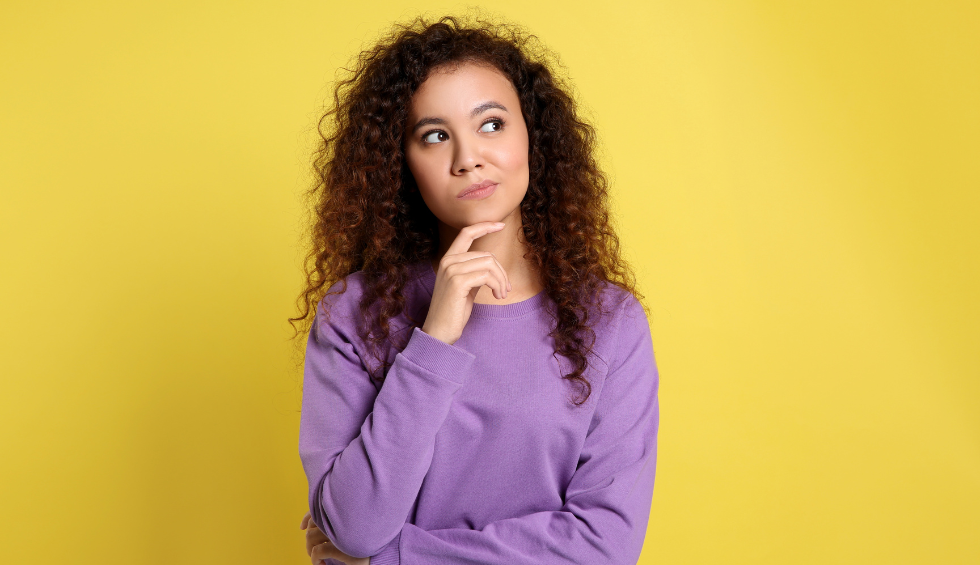 A thoughtful woman in a purple sweater pondering a choice, representing “Why Choose Dispensary Near Me Now?