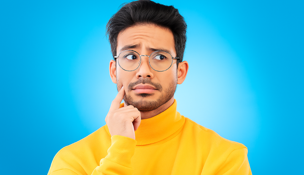 Confused man in yellow sweater looking concerned and touching his face, representing issues with a disposable weed pen not working