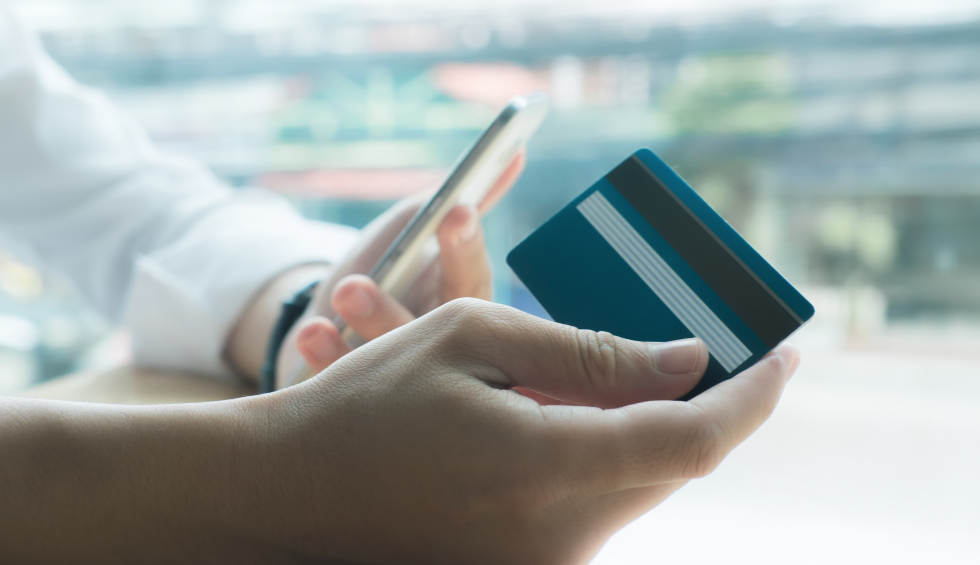 Person holding a smartphone and credit card, ready to buy cannabis from an online dispensary in Vancouver
