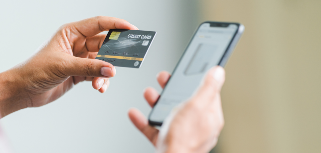 Person holding a credit card and smartphone, ready to buy low price buds online from DispensaryNearMeNow