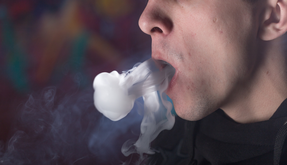 Person exhaling thick vapor cloud, demonstrating one method of consuming live rosin through inhalation