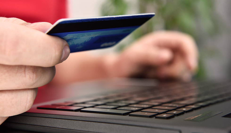 Close-up of a person using a credit card to make a purchase on a laptop, representing how to order weed online in Canada