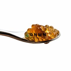 Black Diamond cannabis caviar extract on spoon with amber oil pearls